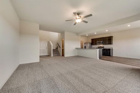 Unfurnished living room with ceiling fan and carpet floors