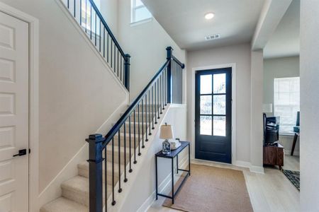 Foyer entrance with visible vents, a towering ceiling, stairway, wood finished floors, and baseboards