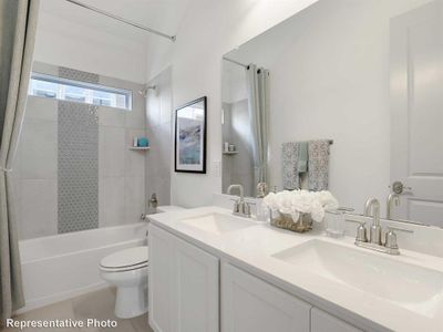 Full bathroom with tile patterned flooring, toilet, tiled shower / bath, and vanity