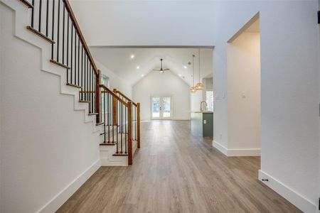 Entrance foyer featuring sink, lofted ceiling, french doors, ceiling fan, and light wood-type flooring