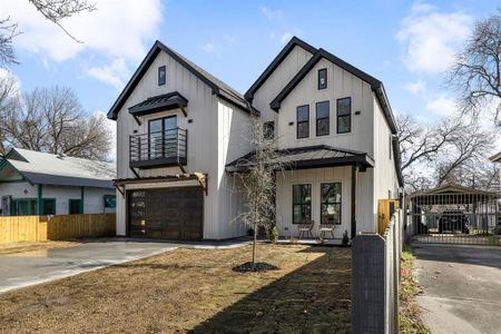 Modern farmhouse featuring driveway, a garage, a balcony, fence, and board and batten siding