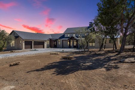 View of front of property with a garage, a standing seam roof, driveway, and metal roof