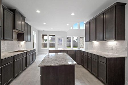 This kitchen is by far any chef’s dream! This spacious kitchen features high ceilings, stained wood cabinets, granite countertops, SS appliances, modern tile backsplash, recessed lighting, extended counter space with double sink and space for breakfast bar and a walk-in pantry all overlooking your huge family room.