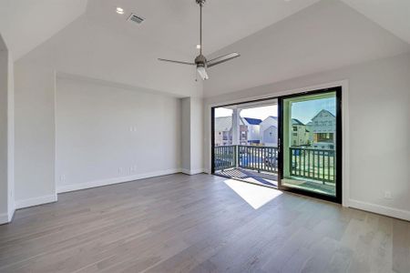 Show Stopping Tri-Paneled Glass Doors lead out from Primary Bedroom to its own Balcony. Bedroom itself is highlighted with Vaulted Ceilings Widand e Plank Wood Floors