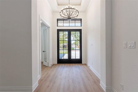 The formal entry has a coffered ceiling accented with a beautiful modern chandelier.