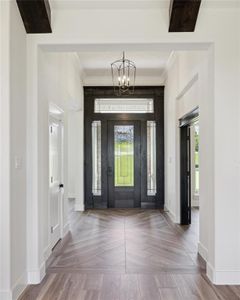 Foyer featuring parquet floors, a notable chandelier, and ornamental molding