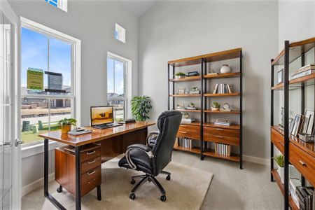 Quietly nestled in front of the home is the handsome home office. Featuring plush carpet flooring, custom paint and a large windows.