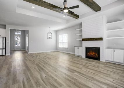 The spacious living room features a fireplace and floating shelves.