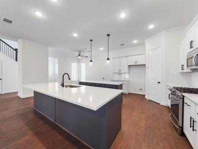 The Warwick Kitchen! Featuring quartz countertops, Benedettini custom cabinets, including a pull-out trash can for added convivence and Moen plumbing fixtures. (Sample photos of a completed Warwick floor plan. The image may feature alternative selections and/or upgrades.)