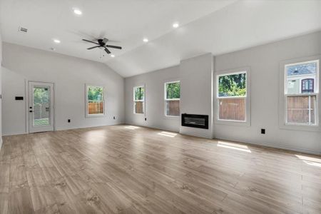 Unfurnished living room with light wood-type flooring, ceiling fan, and lofted ceiling