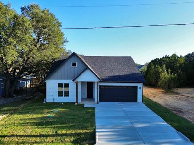 View of front facade featuring a garage and a front lawn