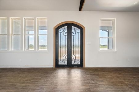 Foyer entrance with beamed ceiling, french doors, and wood-type flooring