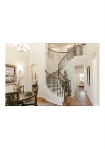 Stairs featuring hardwood / wood-style flooring, a towering ceiling, and an inviting chandelier