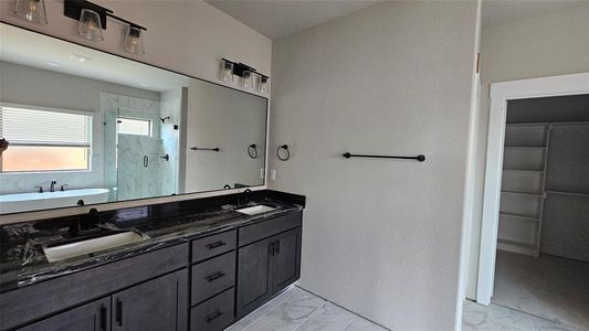 Bathroom featuring double vanity, tile patterned floors, and plus walk in shower