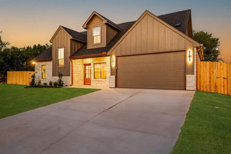 View of front facade featuring a garage and a lawn