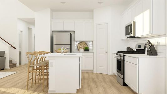 Kitchen featuring white cabinets, light wood-type flooring, appliances with stainless steel finishes, and a center island with sink