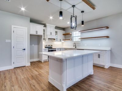 Kitchen with white cabinets, a center island, and light hardwood / wood-style flooring