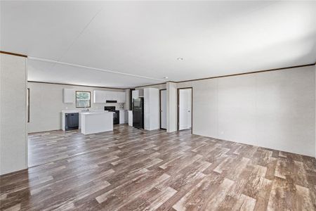 Unfurnished living room with sink, crown molding, and wood-type flooring