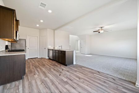 Kitchen featuring stainless steel appliances, an island with sink, light hardwood / wood-style flooring, sink, and ceiling fan