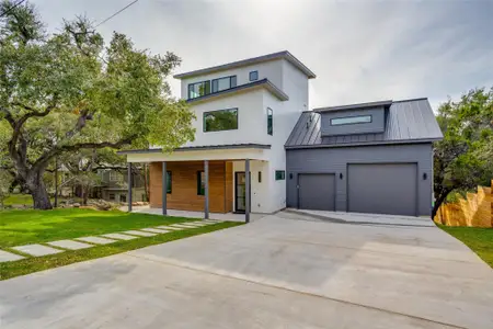 Contemporary house featuring a front lawn, a garage, and covered porch