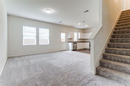 Unfurnished living room featuring light carpet