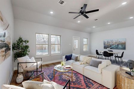 Living room featuring hardwood / wood-style floors, a fireplace, a healthy amount of sunlight, and ceiling fan