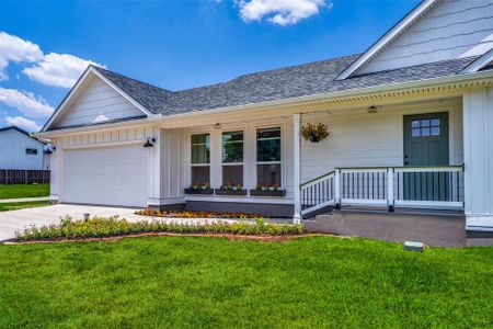 View of front of home with a garage and a front lawn