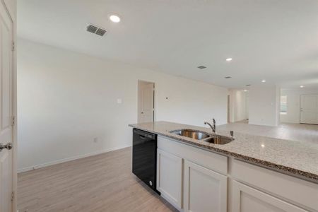 Kitchen with sink, light hardwood / wood-style flooring, light stone countertops, dishwasher, and white cabinetry