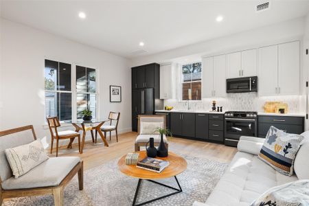 Living room featuring sink, light hardwood / wood-style floors, and plenty of natural light