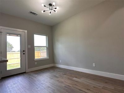 Dining room area with tons of natural light. Modern light fixture. Adjustable blind integrated in the door leading to the fenced backyard.