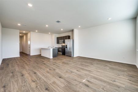 Kitchen featuring a kitchen island with sink, sink, light wood-type flooring, and appliances with stainless steel finishes