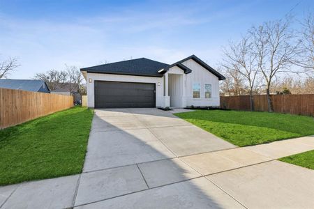 View of front of property featuring a 2 car garage and a front lawn