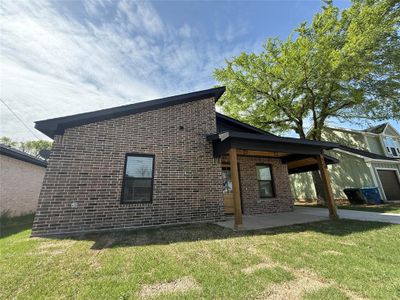 Rear view of house featuring a patio, brick siding, and a lawn Rear view of house featuring a patio, brick siding, and a lawn