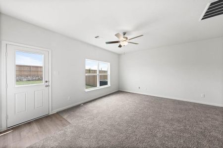 Carpeted living room with a wealth of natural light and ceiling fan