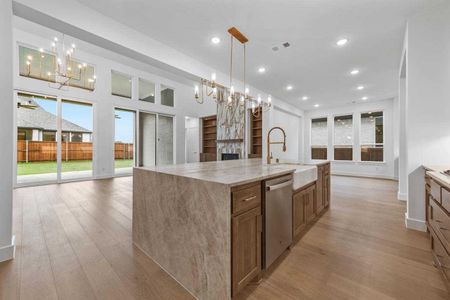 Kitchen featuring sink, hanging light fixtures, stainless steel dishwasher, and a spacious island