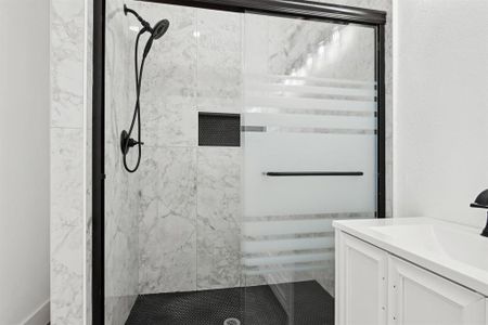 Bathroom featuring a shower stall and vanity