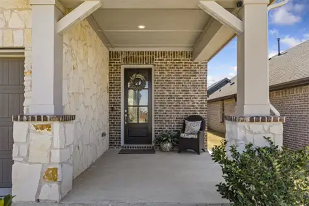 Entrance to property featuring stone siding and brick siding