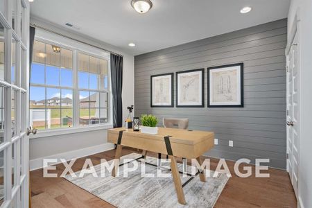 Office space featuring hardwood / wood-style floors, wooden walls, and french doors