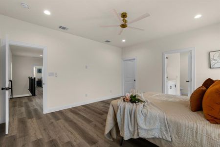 Bedroom featuring dark hardwood / wood-style floors, ceiling fan, and ensuite bathroom