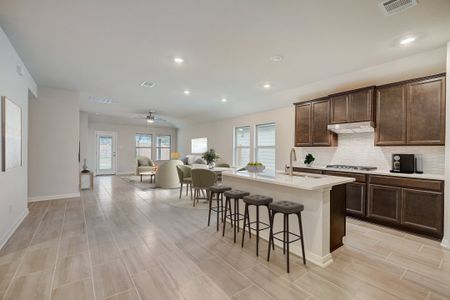 Virtually staged kitchen, dining, & living in the Oleander floorplan at a Meritage Homes community.