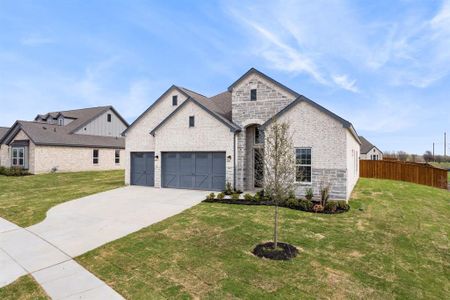 View of front facade featuring a front lawn and a garage