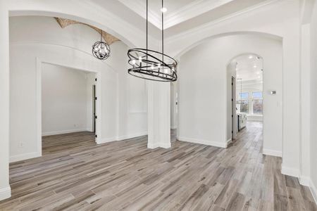 Dining area with crown molding and custom flooring