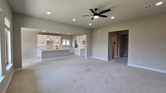 Unfurnished living room with sink and ceiling fan