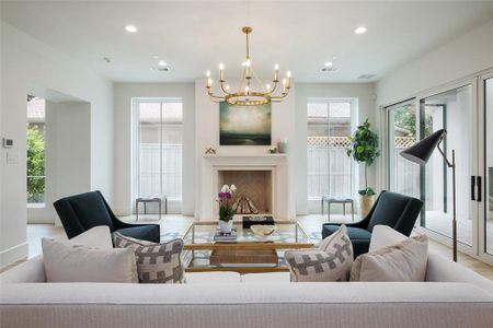 Living room with light wood-type flooring and a chandelier