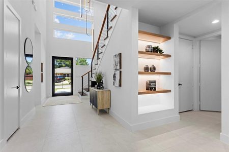 Entryway featuring a high ceiling and light tile patterned flooring