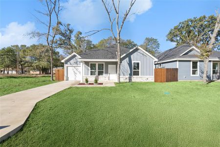 View of front facade featuring a garage and a front yard