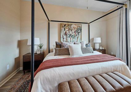 Bedroom with large cozy bed and two side tables and an ottoman