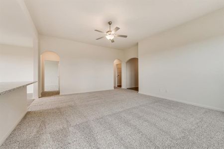 Carpeted spare room featuring ceiling fan