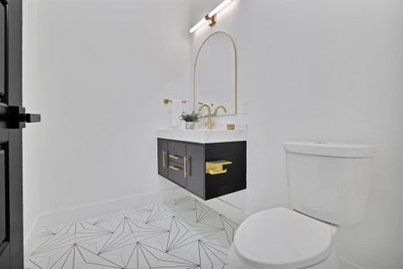 Bathroom featuring tile patterned flooring, vanity, and toilet