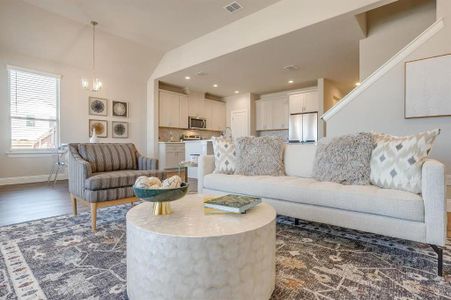 Living room featuring lofted ceiling, dark wood-type flooring, and a notable chandelier